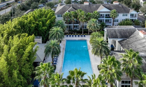 a pool surrounded by trees and buildings